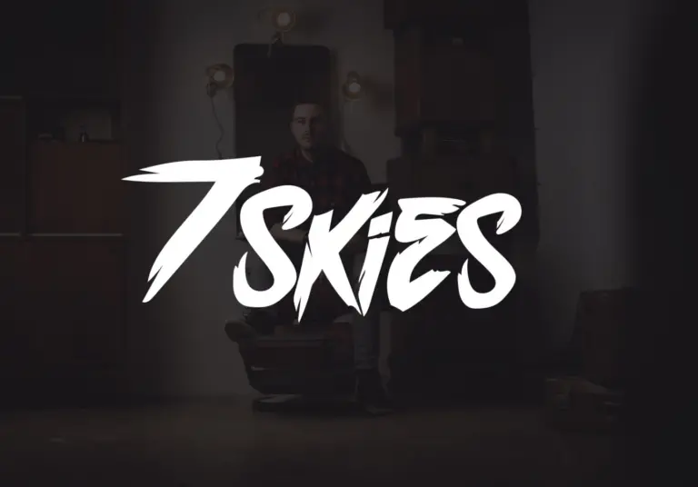 7 skies - a man sitting on a chair in a dark room, engrossed in his music production program.