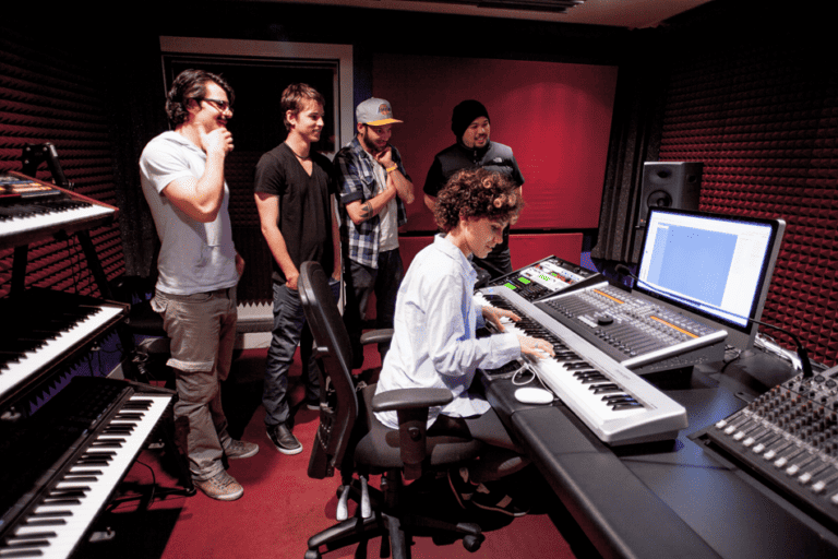 A music producer and their team are working together in a recording studio.