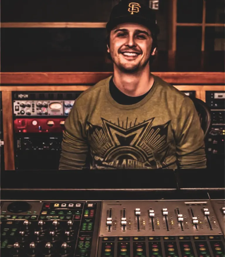 A man smiling in front of a beatmaking.