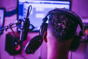 Man on microphone with back of head in studio