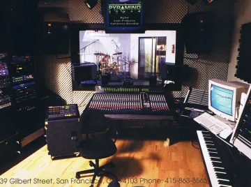 A music producer's recording studio equipped with a keyboard and a monitor, perfect for beatmaking, mixing, and mastering.